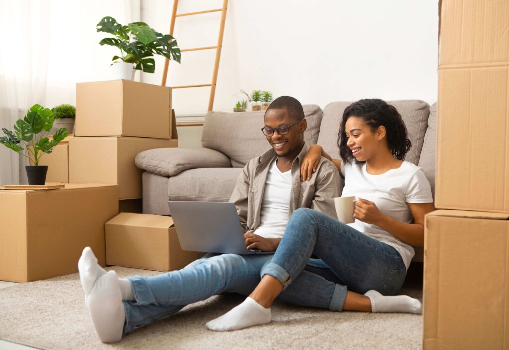 couple relaxing after moving with boxes